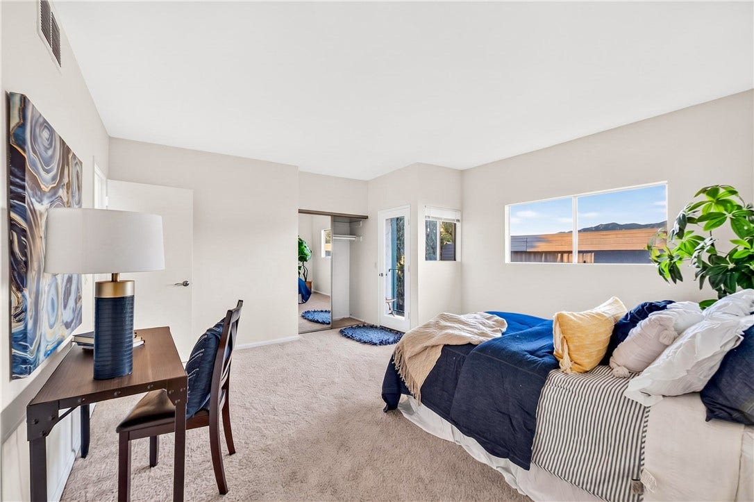 Bright bedroom features generous proportions, multiple windows, and comfortable living space.