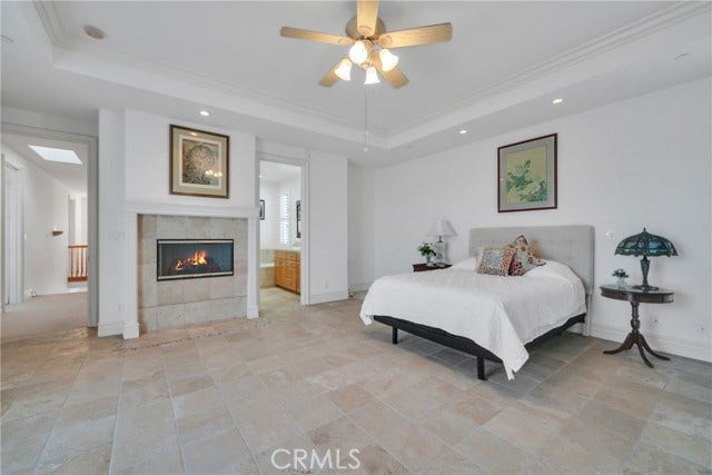 Oversized primary bedroom with fireplace and bath.