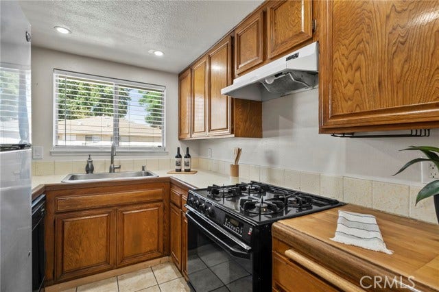 3125 N White AVE, #4, La Verne, CA 91750 Another view of the kitchen showcasing generous cabinet and counter space, gas range and a bright window over the sink.