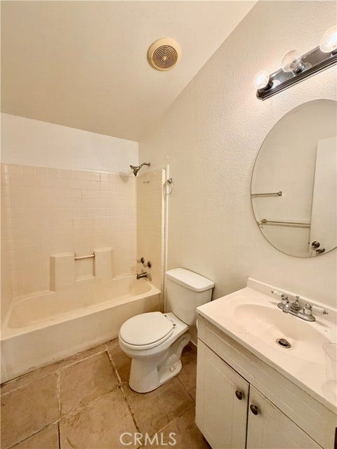 Bathroom with a tub-and-shower combination and vanity.