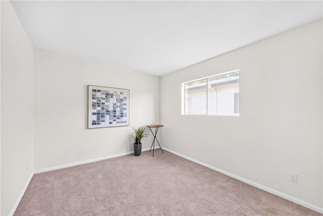Comfortable bedroom features plush carpeting, natural light, and a spacious floor plan.