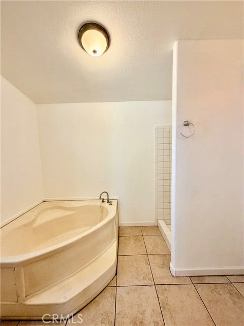 Masterroom's bathroom spacious soaking tub with a separate shower alongside.