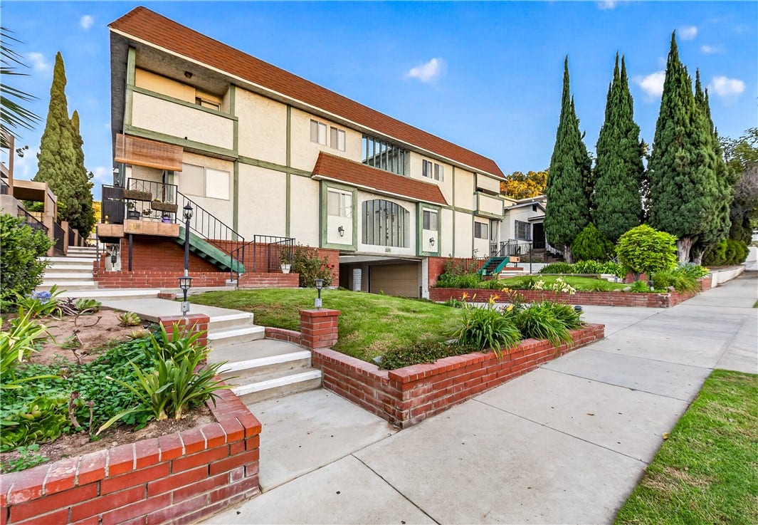 Landscaped walkways and mature greenery complement the residence s classic architectural design.