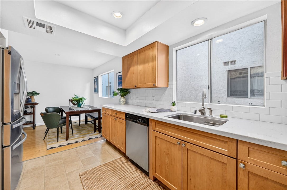 Bright kitchen includes stainless-steel appliances, ample cabinetry, and a dedicated dining area.