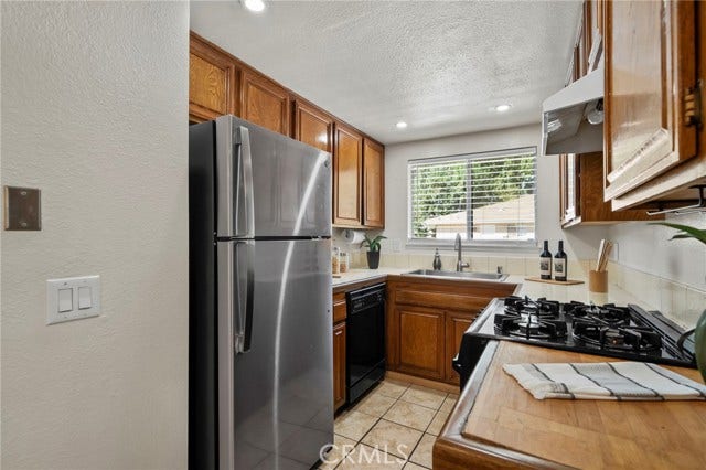 3125 N White AVE, #4, La Verne, CA 91750 Functional kitchen featuring abundant cabinetry, full-size appliances, recessed lighting and a window bringing in plenty of natural light.