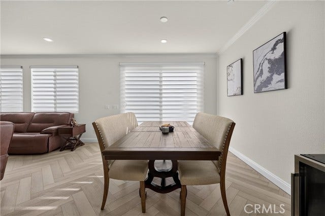 Dining area in front of sliders leading to backyard